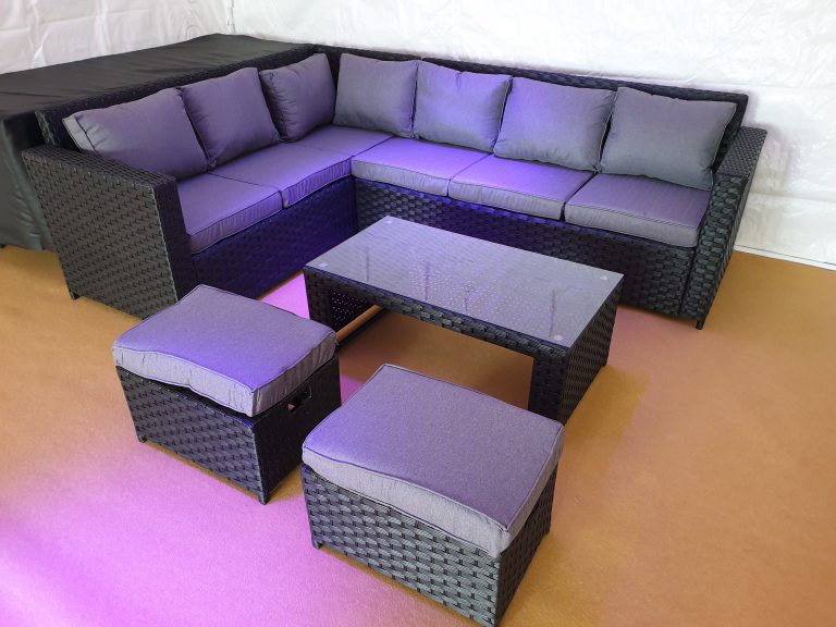 Rattan corner suite with coffee table and stools inside a marquee