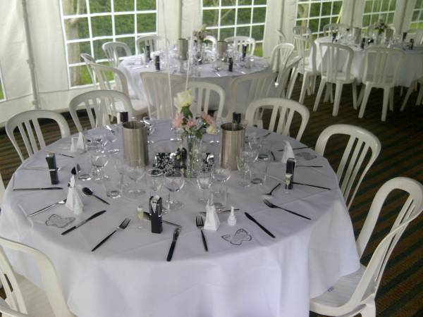 Covered tables with with bistro chairs and flower centre pieces