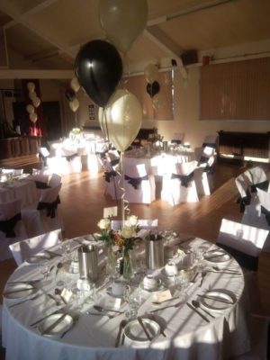 Covered tables with chairs and chair covers with black organza bows