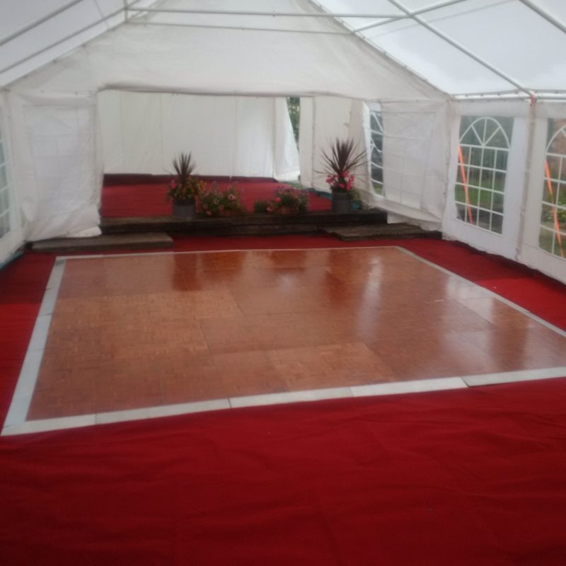 Parque dance floor on red cord carpet inside a marquee