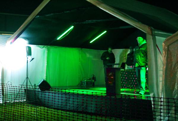 Stage units covered with a marquee with green lights
