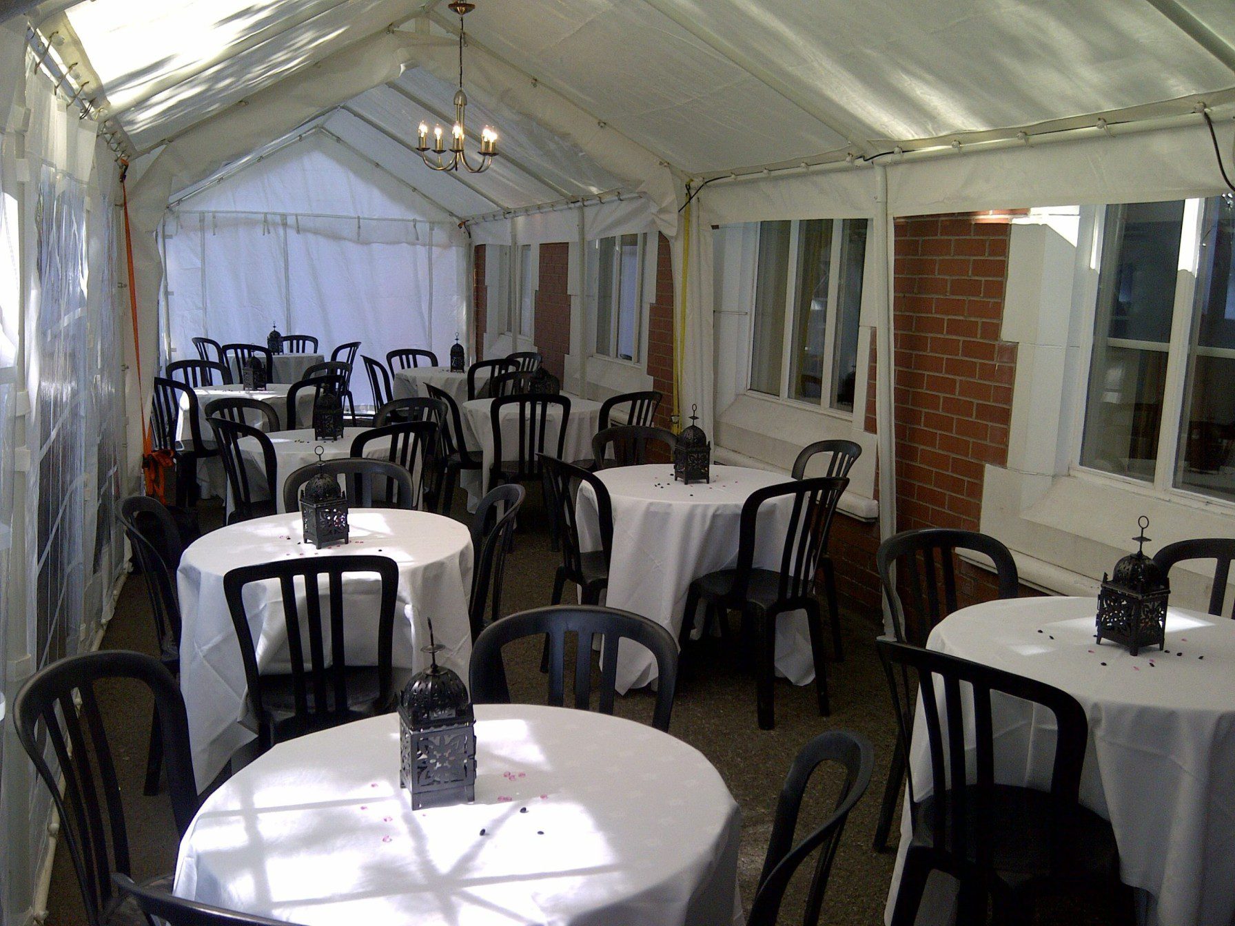 Tables and black bistro chairs inside marquee
